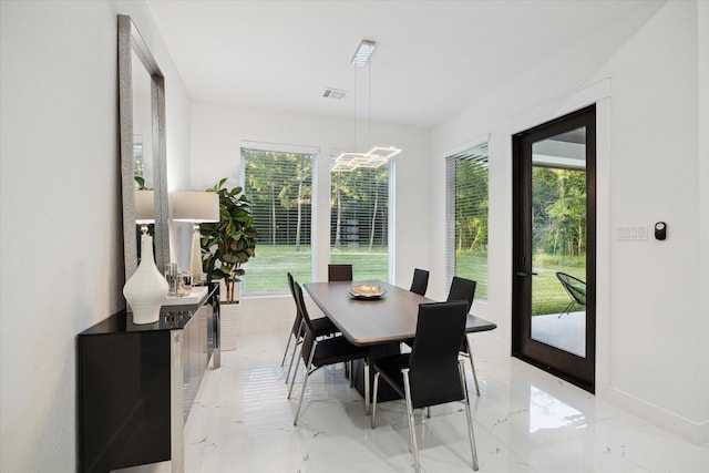 dining room featuring plenty of natural light, a notable chandelier, visible vents, and marble finish floor