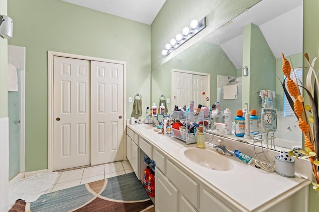 full bathroom featuring a sink, tile patterned flooring, a shower with shower door, and double vanity