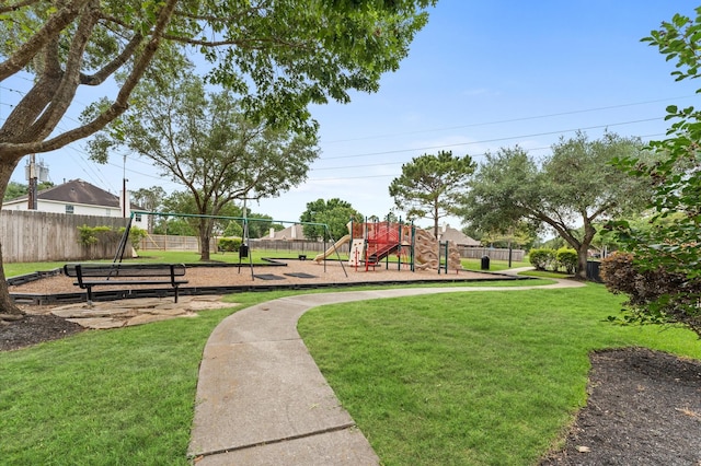 community jungle gym with a yard and fence
