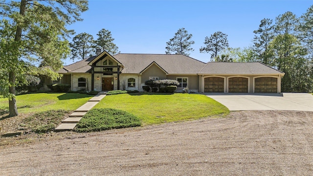 view of front facade with a chimney, concrete driveway, an attached garage, a tile roof, and a front yard