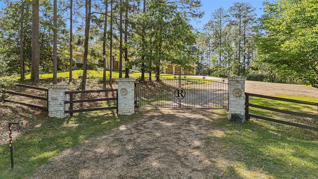 view of gate with fence and a yard