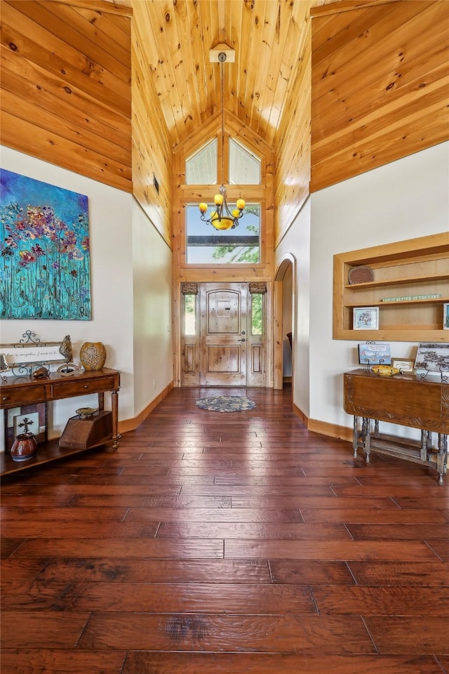 foyer featuring high vaulted ceiling, wood-type flooring, baseboards, and arched walkways