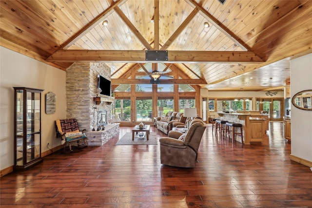 living area featuring a wealth of natural light, a ceiling fan, dark wood-style floors, and baseboards