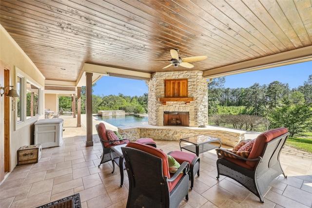 view of patio with an outdoor living space with a fireplace and ceiling fan