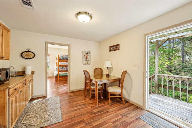 dining area with baseboards, visible vents, and light wood-style flooring