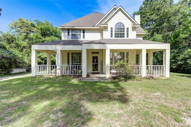farmhouse inspired home with a chimney, a porch, a shingled roof, and a front yard