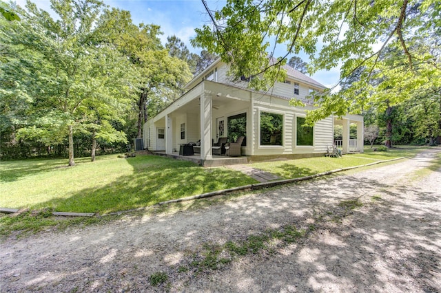 rear view of property featuring cooling unit, a patio area, and a lawn