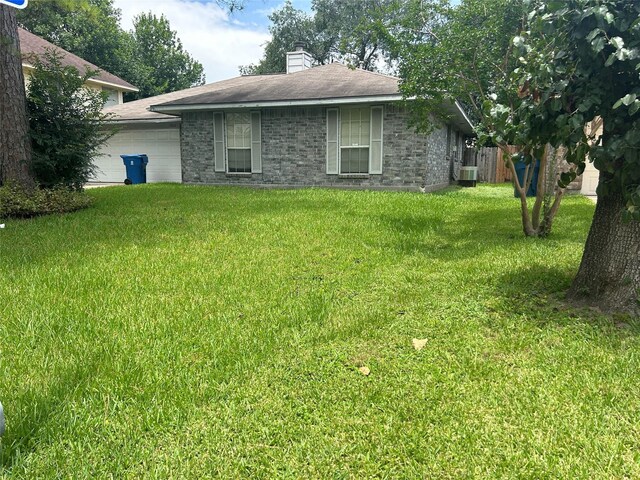 7810 Sawmill Trl, Houston, TX 77040 - view of grassy yard featuring an attached garage and central AC
