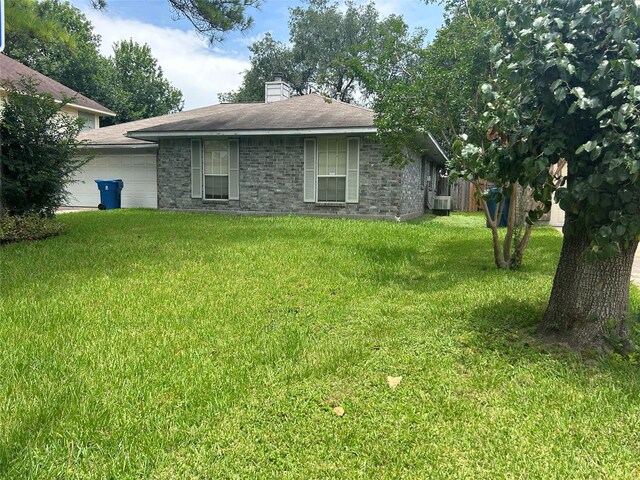 7810 Sawmill Trl, Houston, TX 77040 - back of property featuring an attached garage, a chimney, and a yard