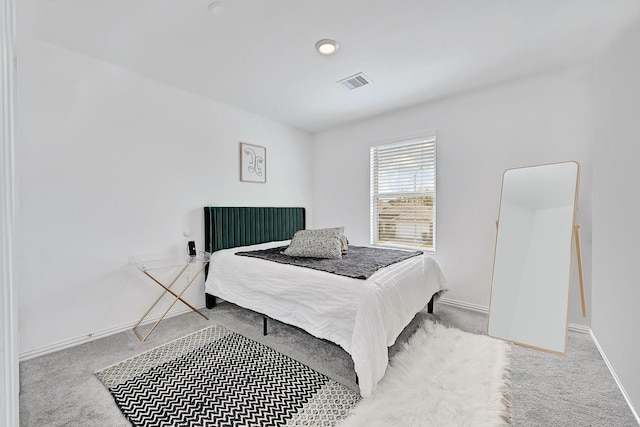 bedroom with carpet floors, visible vents, and baseboards