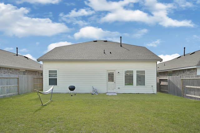 back of house featuring a fenced backyard and a yard
