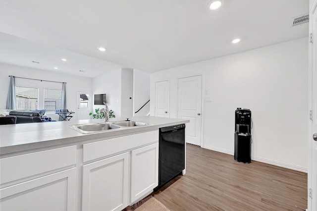 kitchen featuring a sink, open floor plan, light wood-style floors, white cabinetry, and black dishwasher