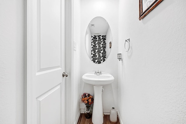 bathroom with baseboards and wood finished floors