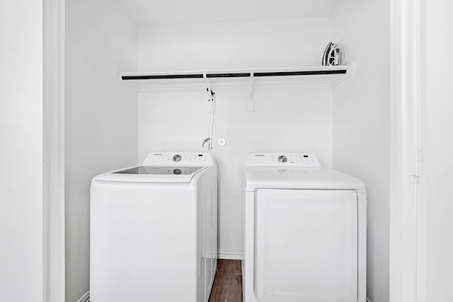washroom with separate washer and dryer, dark wood-style floors, and laundry area