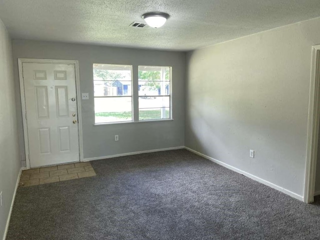entrance foyer with visible vents, baseboards, carpet flooring, and a textured ceiling
