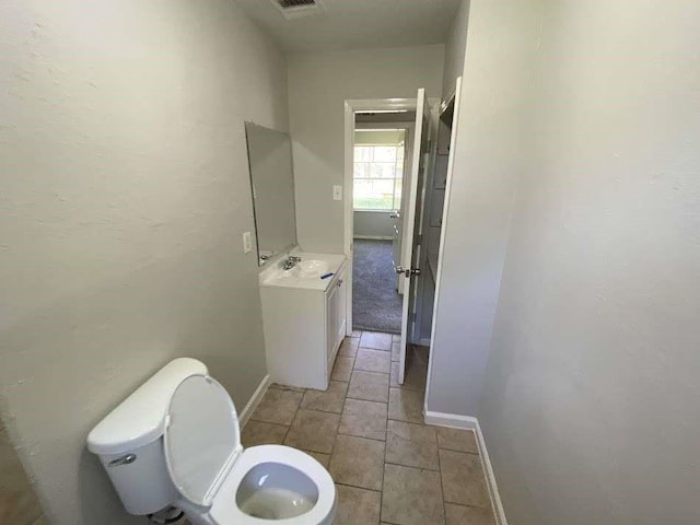 bathroom featuring vanity, toilet, and baseboards