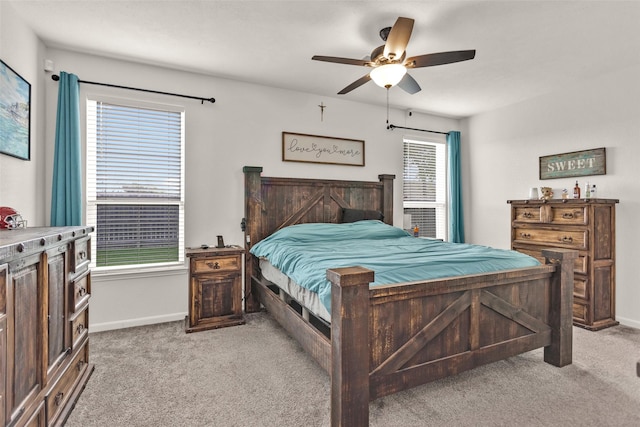 bedroom featuring light colored carpet, baseboards, and a ceiling fan