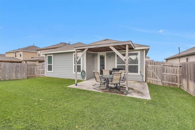 rear view of property featuring a lawn, a patio area, and a fenced backyard