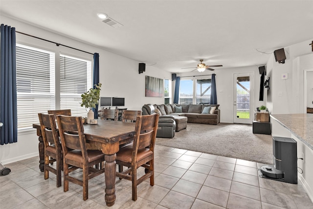 dining room with light tile patterned floors, ceiling fan, light colored carpet, baseboards, and visible vents