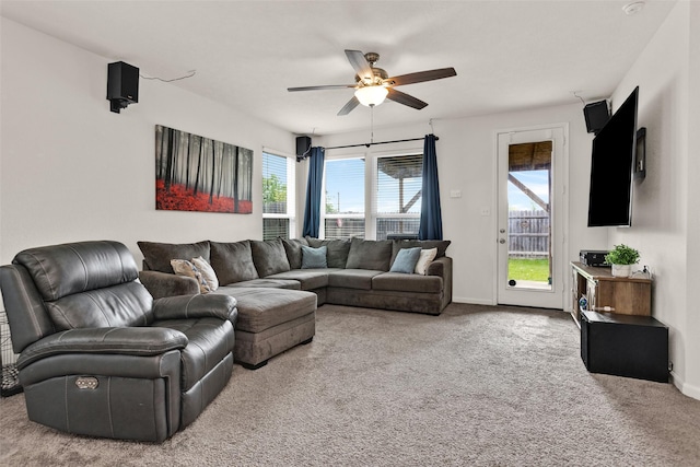 carpeted living room with plenty of natural light, a ceiling fan, and baseboards