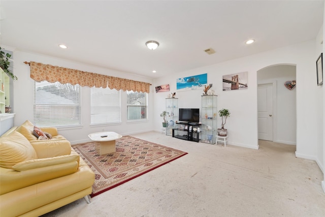 living area with carpet, baseboards, arched walkways, and recessed lighting