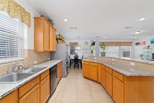 kitchen with a wealth of natural light, tasteful backsplash, black dishwasher, and a sink