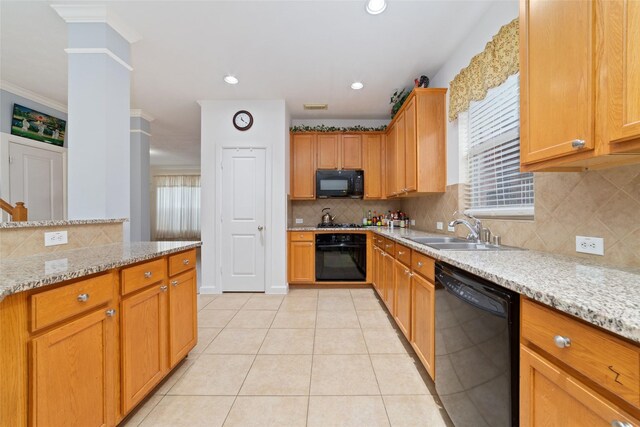 kitchen featuring light tile patterned floors, a sink, black appliances, and tasteful backsplash