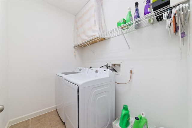 clothes washing area featuring light tile patterned floors, baseboards, laundry area, and independent washer and dryer