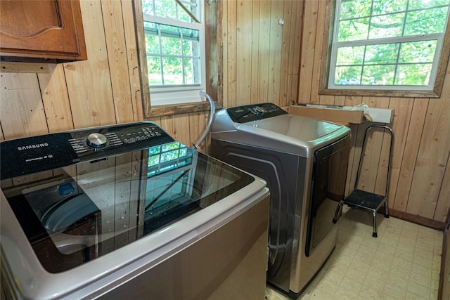 120 Sugar Ln, Lufkin, TX 75904 - clothes washing area featuring cabinet space, wood walls, washer and dryer, and light floors