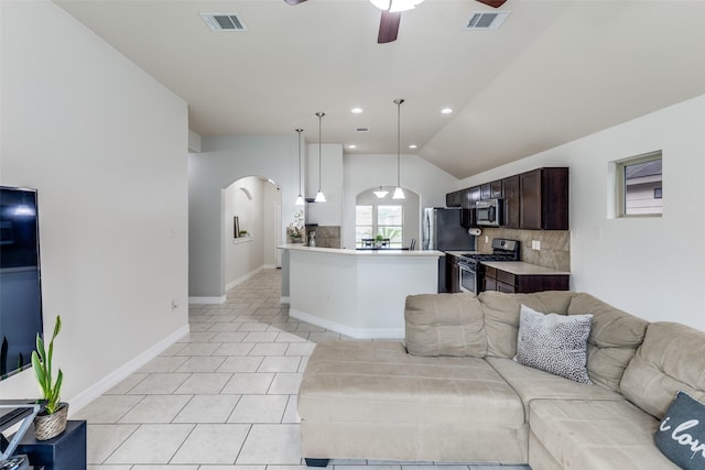 living room with lofted ceiling, visible vents, a ceiling fan, light tile patterned floors, and arched walkways