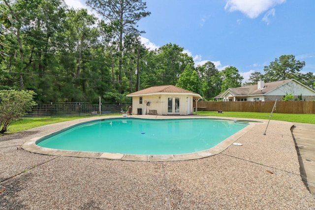9 Slover Dr, Dayton, TX 77535 - view of swimming pool with french doors, a fenced in pool, a fenced backyard, and a lawn