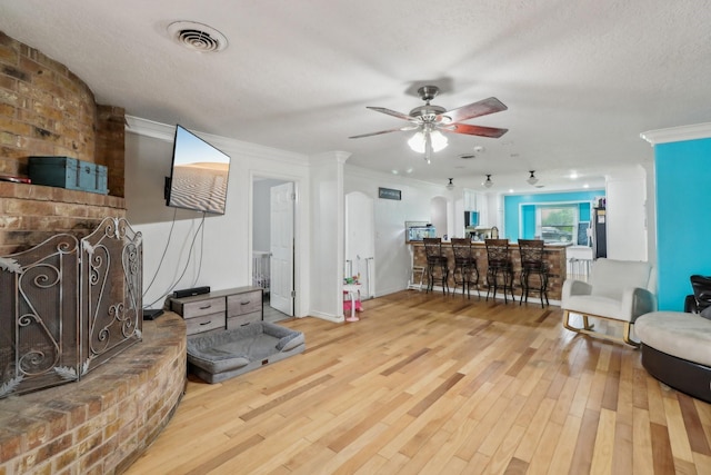 9 Slover Dr, Dayton, TX 77535 - living area with a textured ceiling, visible vents, a ceiling fan, wood finished floors, and crown molding