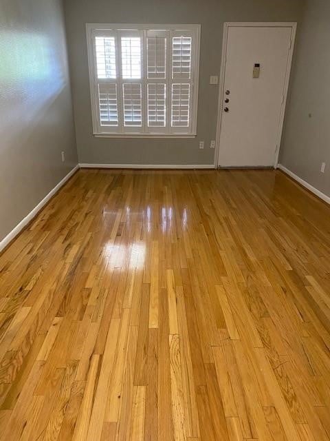 2250 Bering Dr Unit 98, Houston, TX 77057 - unfurnished living room with baseboards and wood finished floors