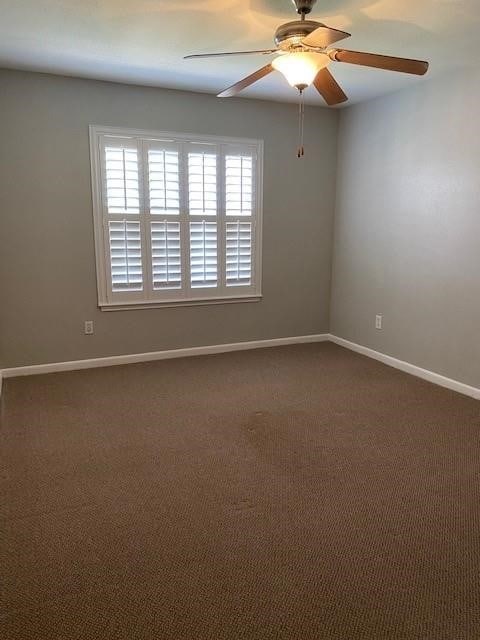 2250 Bering Dr Unit 98, Houston, TX 77057 - empty room with dark colored carpet, a ceiling fan, and baseboards