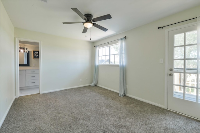 unfurnished bedroom featuring a ceiling fan, baseboards, light carpet, and ensuite bathroom