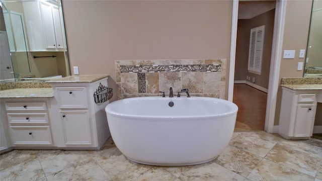 26 Royal Dalton Cir, Conroe, TX 77304 - bathroom with vanity, baseboards, and a soaking tub