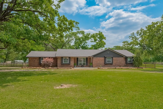 single story home with fence, brick siding, and a front yard