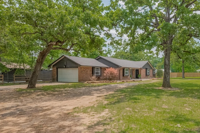 single story home featuring brick siding, an attached garage, driveway, and fence
