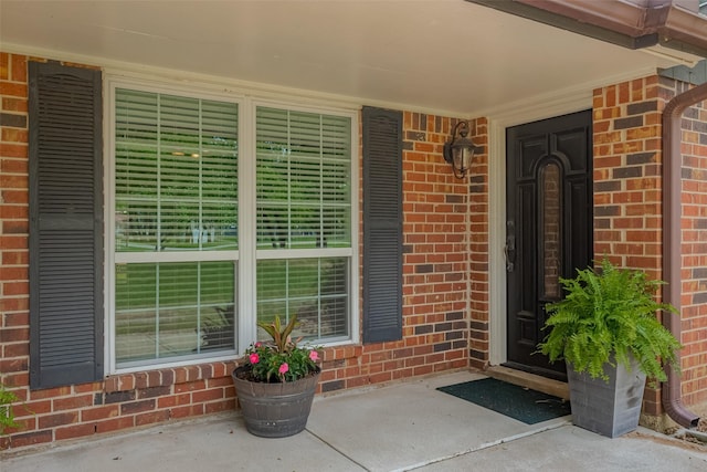 entrance to property featuring brick siding