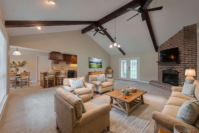 living area with beam ceiling, light colored carpet, and ceiling fan
