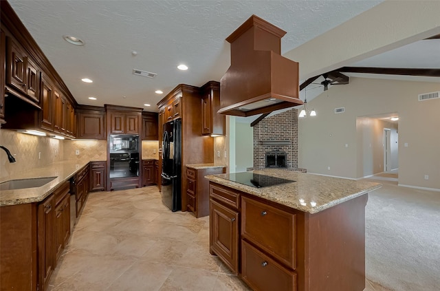 kitchen featuring a sink, visible vents, a ceiling fan, black appliances, and premium range hood