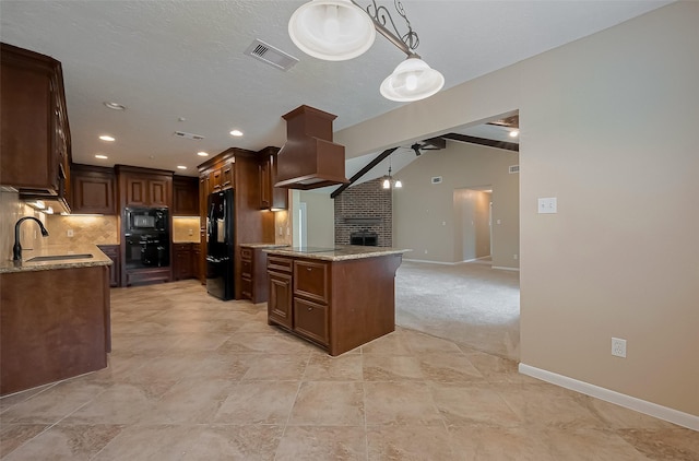 kitchen with a ceiling fan, a sink, premium range hood, a brick fireplace, and visible vents