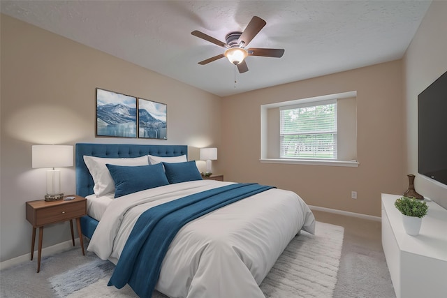bedroom with a ceiling fan, baseboards, and light colored carpet