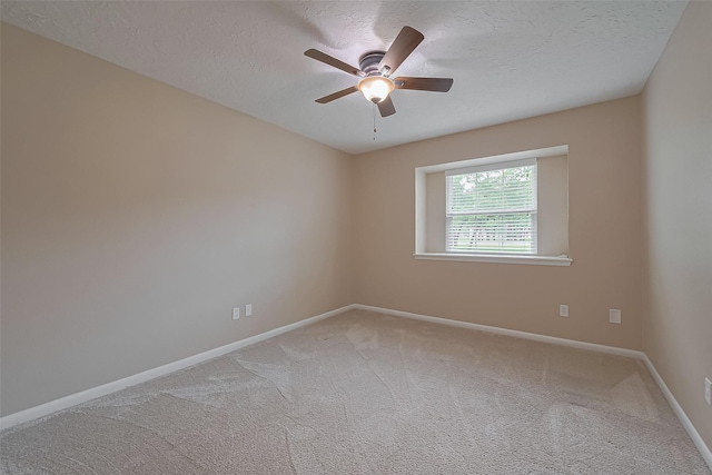 spare room featuring a textured ceiling, carpet flooring, baseboards, and a ceiling fan