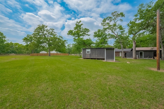 view of yard featuring fence and an outdoor structure