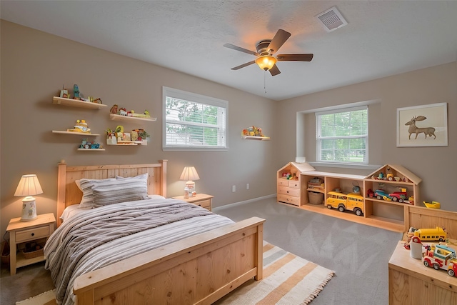 bedroom featuring multiple windows, visible vents, baseboards, and light carpet