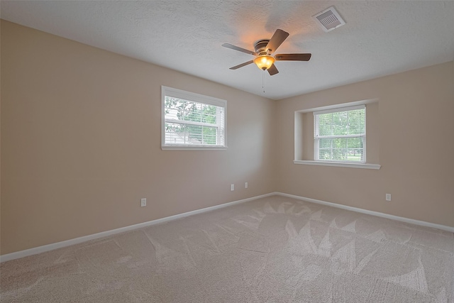 empty room with baseboards, light carpet, visible vents, and a healthy amount of sunlight