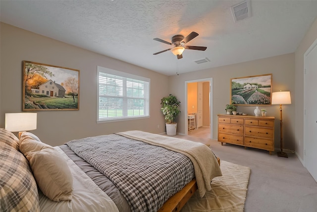 bedroom with light colored carpet, ceiling fan, baseboards, and visible vents