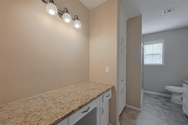 bathroom with tile patterned floors, toilet, baseboards, visible vents, and vanity