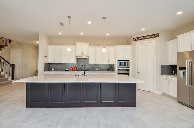 1310 Layla Sage Loop, Richmond, TX 77406 - kitchen featuring decorative backsplash, a spacious island, appliances with stainless steel finishes, a sink, and white cabinetry